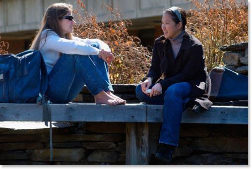 two students talking on bench